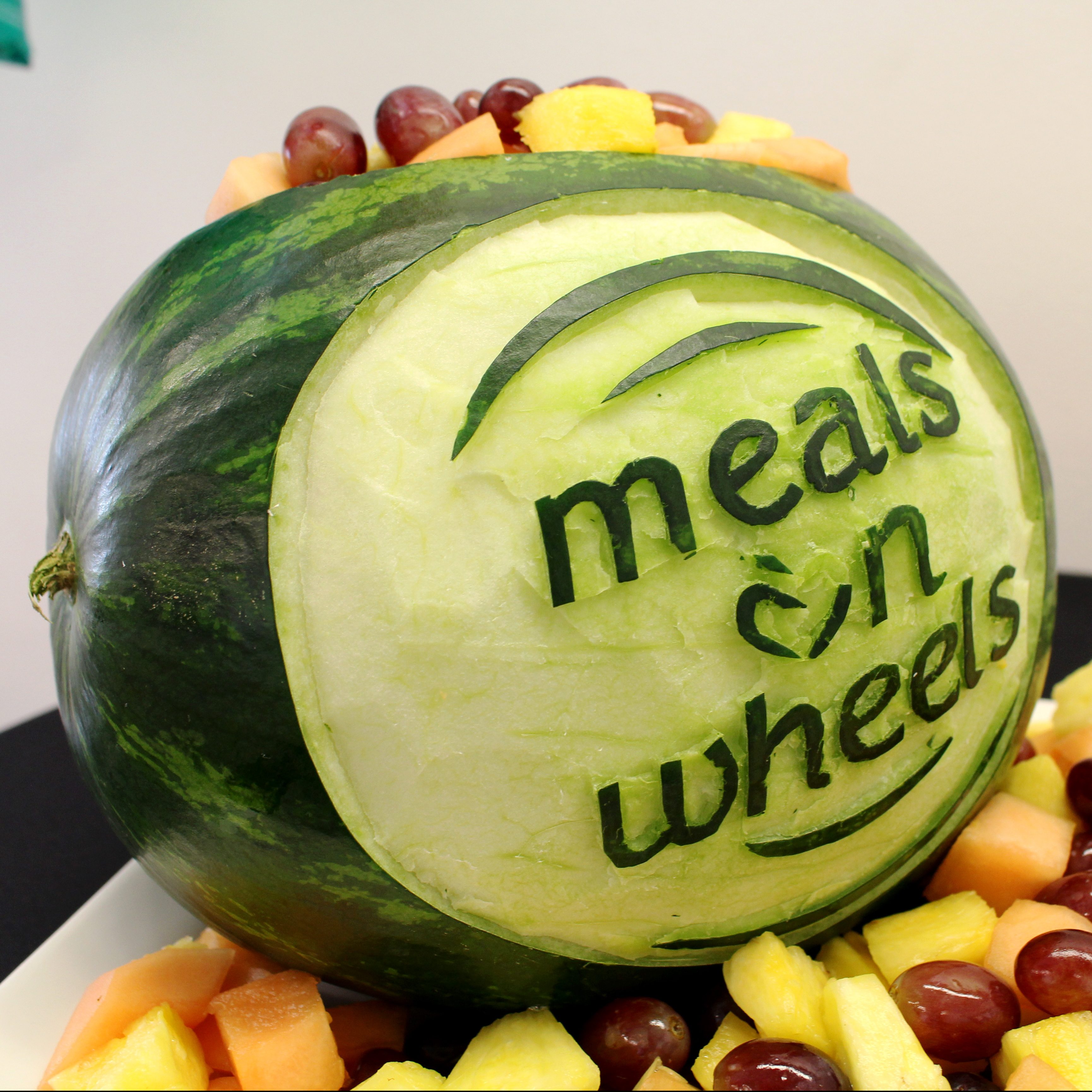 El chef Kris Almsted talló esta sandía con el logotipo de Meals on Wheels para la Gran Inauguración de Kitchen of Opportunities