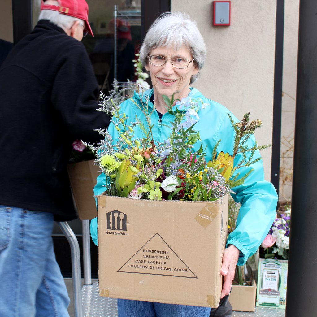 A volunteer holding a box of flowers