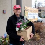Un voluntario sostiene una caja, medio vacía por haber dado flores.