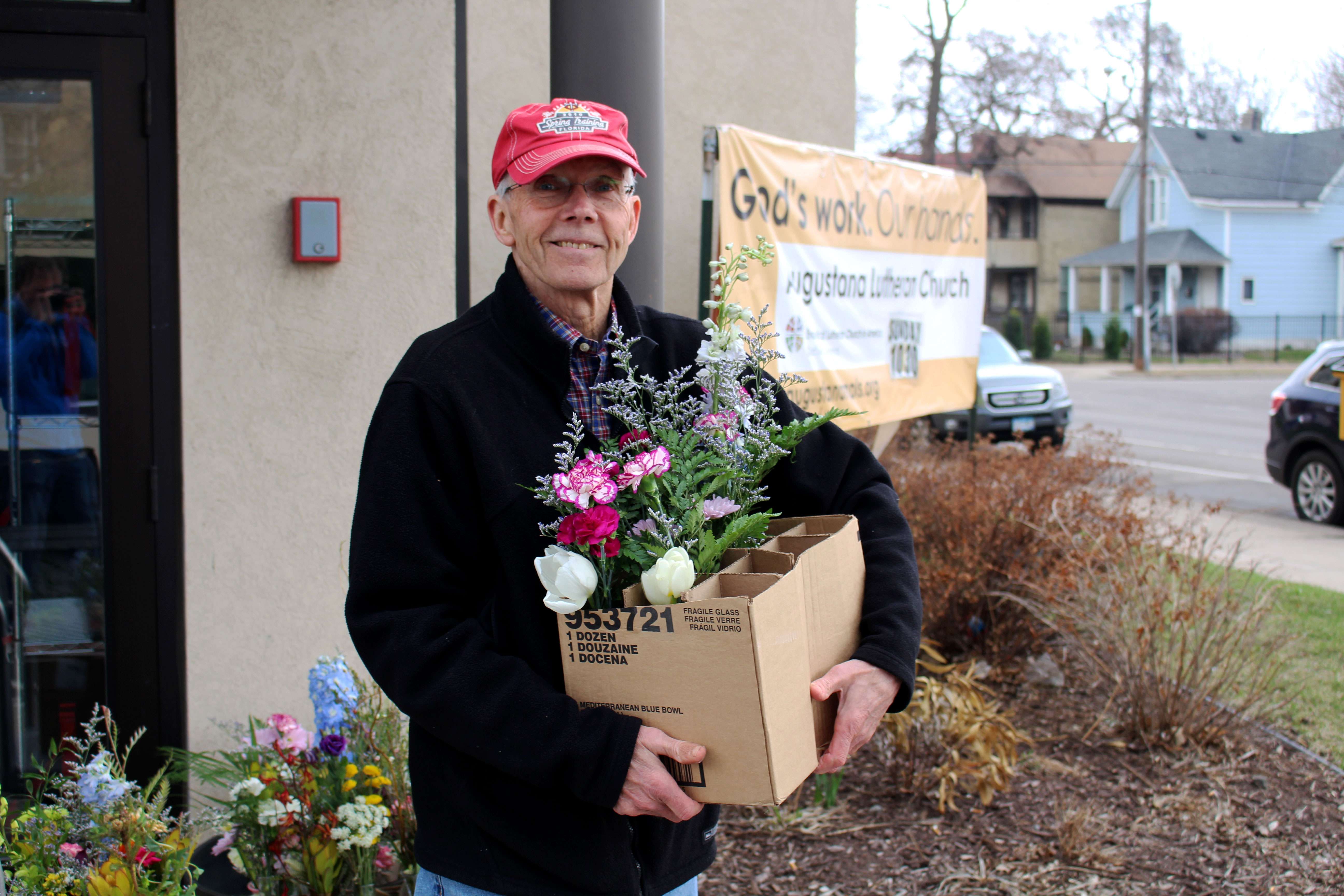 A volunteer holds a box, half empty from giving flowers
