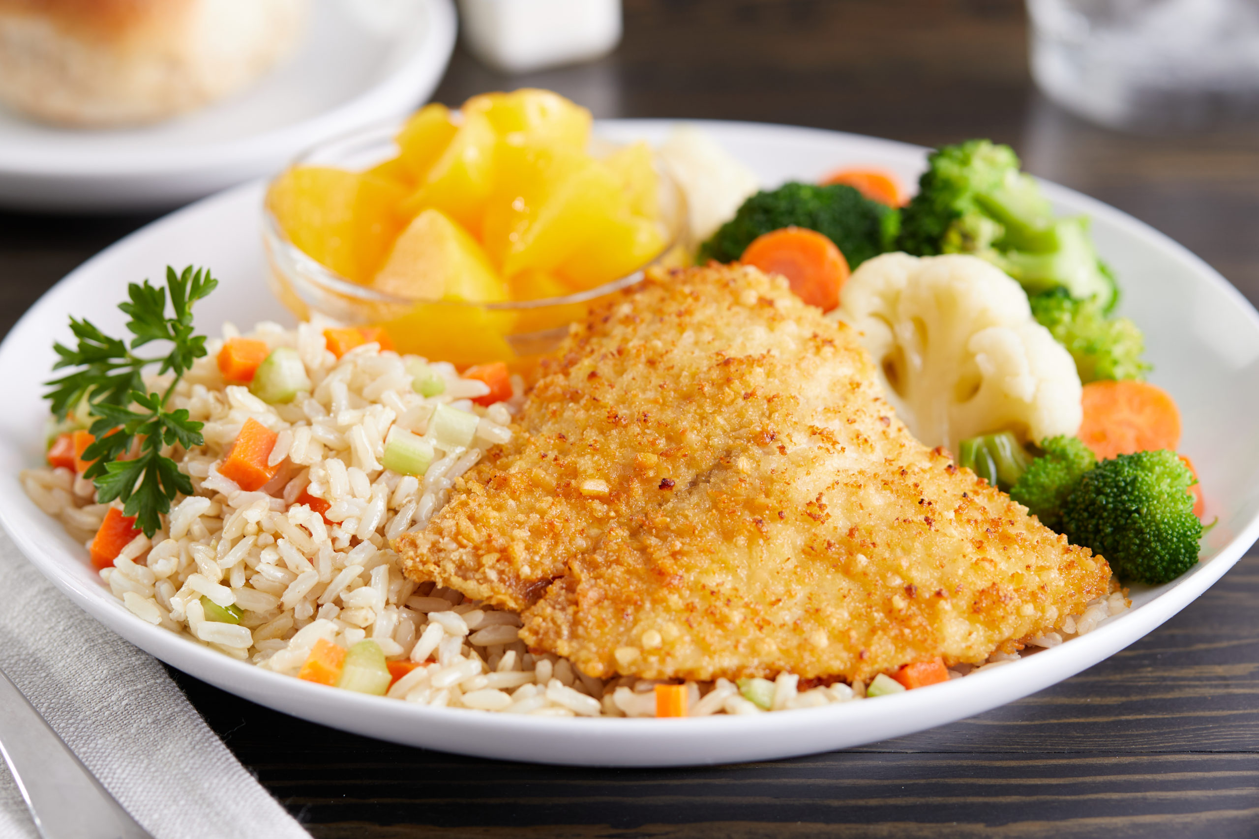 Fish parmesan meal with fruit and veggies