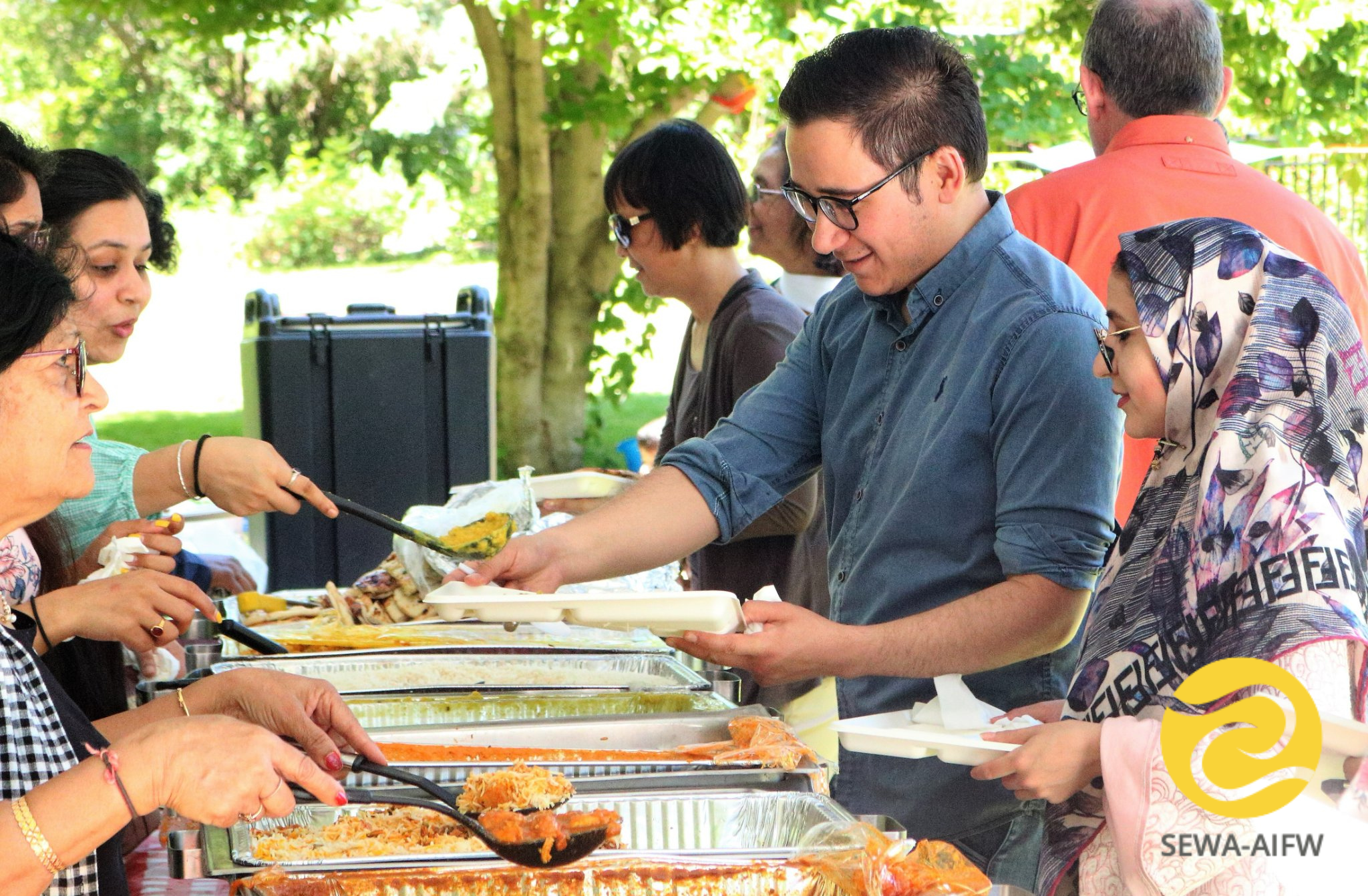 Guests dish up food at a SEWA event