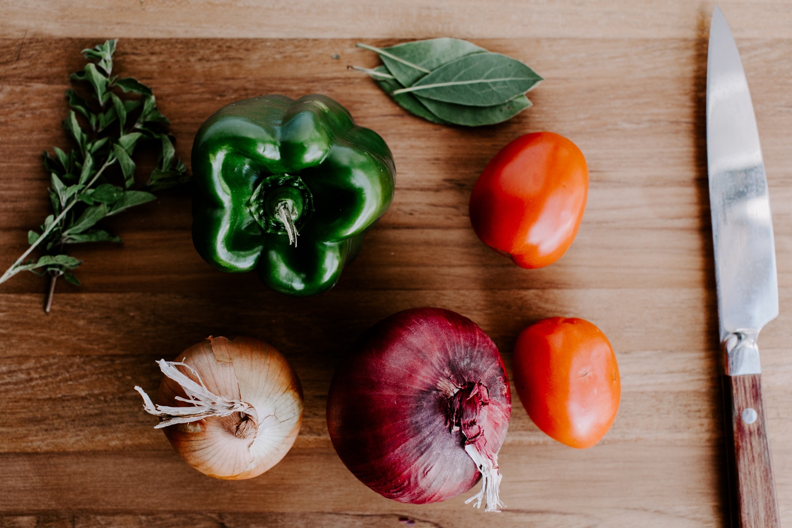 Verduras frescas en una tabla de cortar con un cuchillo. Conozca cómo los beneficios de EBT de Minnesota pueden ayudarlo a obtener los beneficios de Meals on Wheels.
