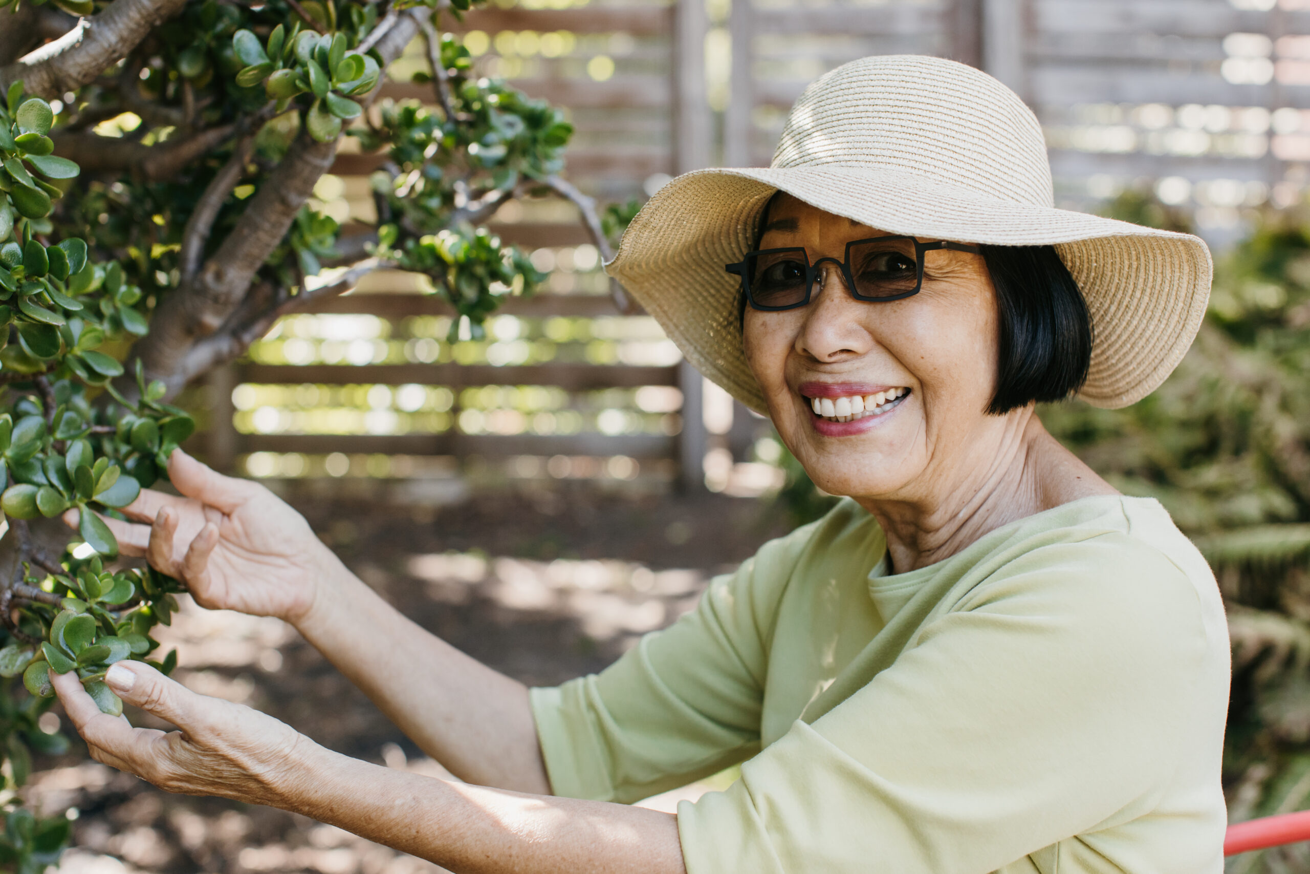 Woman gardening wearing hat and clothing to stay cool.